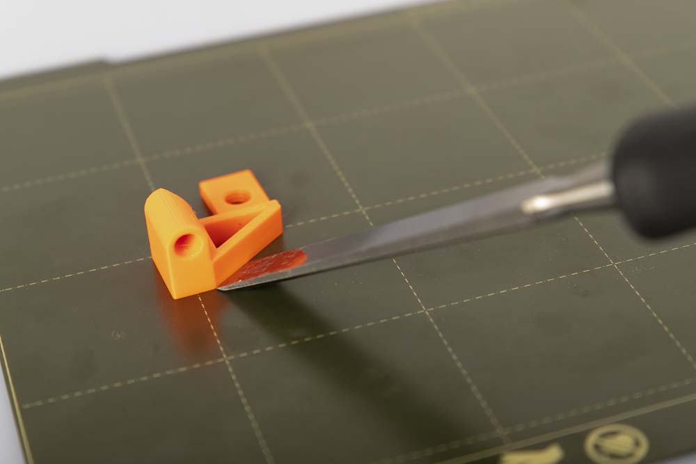 Zum ablösen eines 3D Druck Bauteils wird ein Stechbeitel verwendet