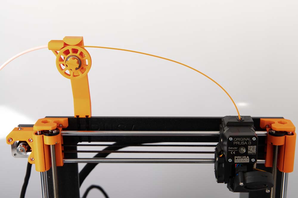 Filament guiding system mounted on the left, 3D printing extruder on the right end of the X axis