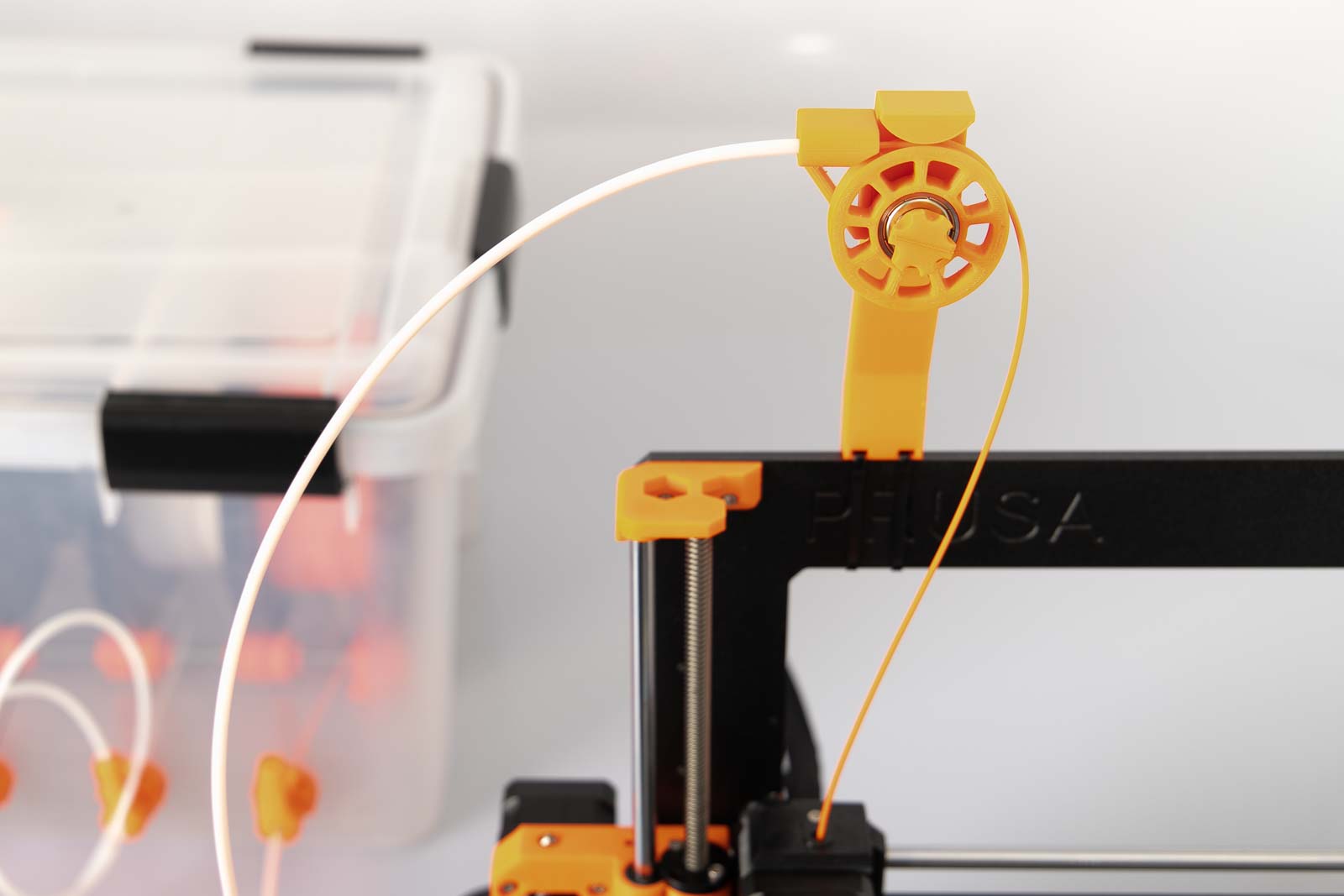 Filament Führung mit Umlenkrolle am 3D Drucker montiert mit Filament Box im Hintergrund
