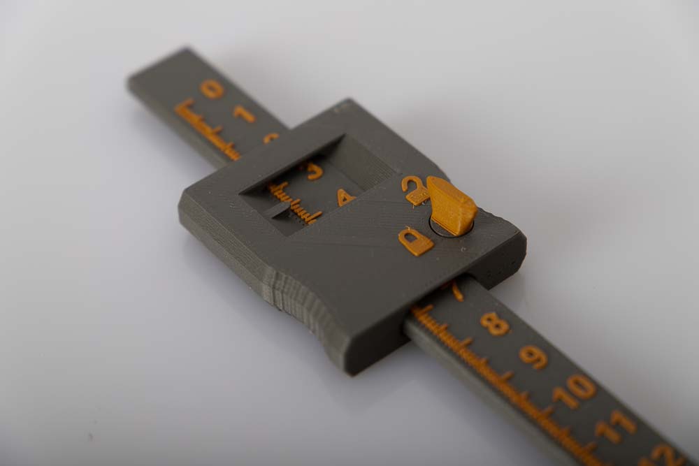 Close-up shot of the 3D printed depth calipers printed in dark gray and gold