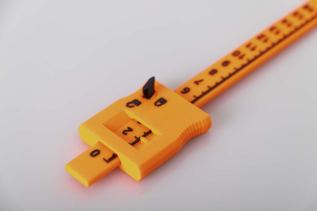 Close-up shot of the 3D printed vernier caliper printed in orange and black