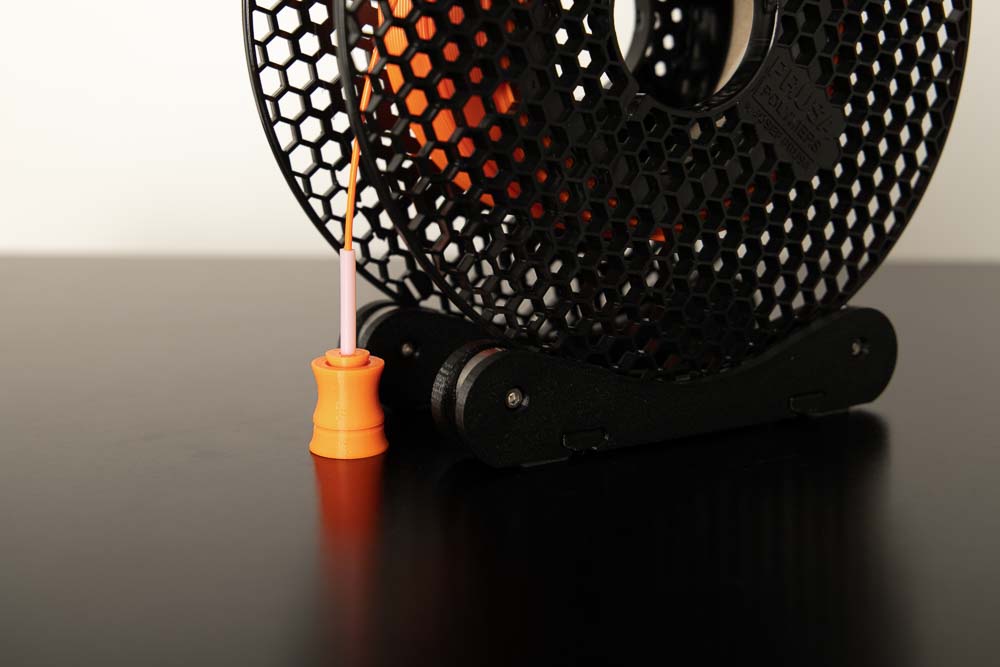 Filament Spule auf Spulenhalter auf der 3D Drucker Einhausung platziert wobei Filament in die Box geführt wird mittels Durchführung Variante A
