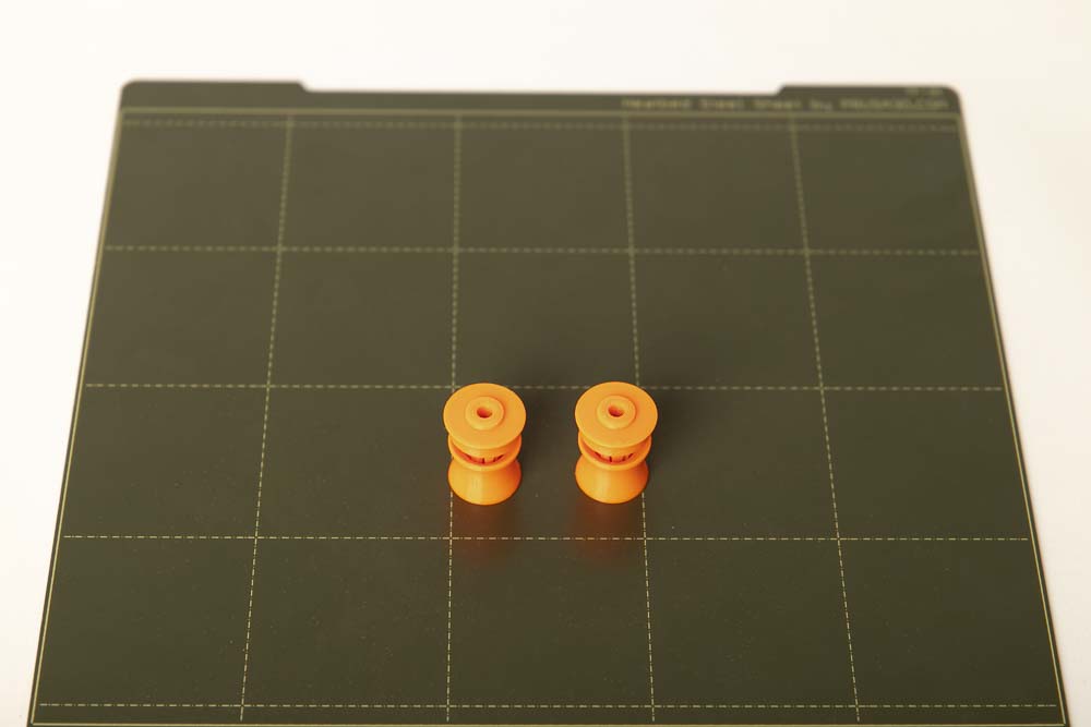Zwei 3D Druck Schlauchklemmen auf einer 3D Drucker Bauplatte