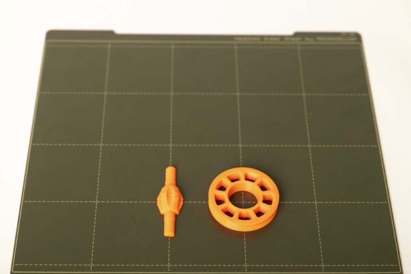 Die 3D Druck Teile Schraube und Umlenkrolle auf einer 3D Drucker Druckplatte