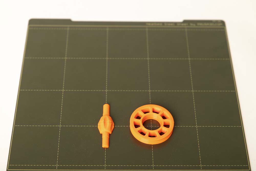 The 3D printed parts split screw and pulley on a 3D printer building plate
