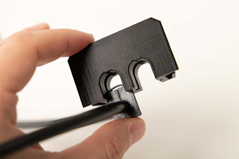 Einsetzen des 3D Druck Inserts in die Kabeldurchführungsbox mit eingesetzten 3D Drucker Stromkabel