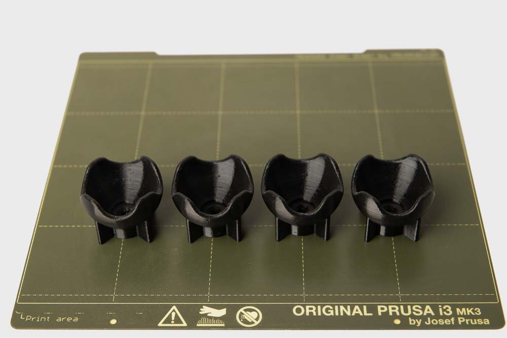 4 Stück 3D gedruckte Squashballhalterungen auf der flexiblen Druckplatte des 3D Druckers