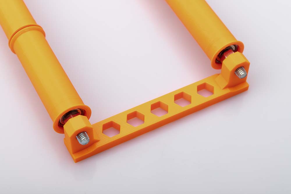 The 3D printed bracket is pushed onto the two M8 threaded rods with mounted wide rollers including ball bearings.