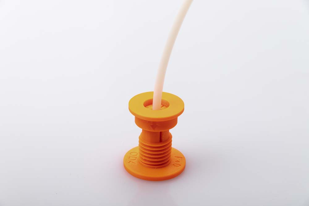 Photo of a PTFE tube that is inserted into the 3D printed filament outlet and is held with a clamping ring, but which is too far from the end of the outlet.