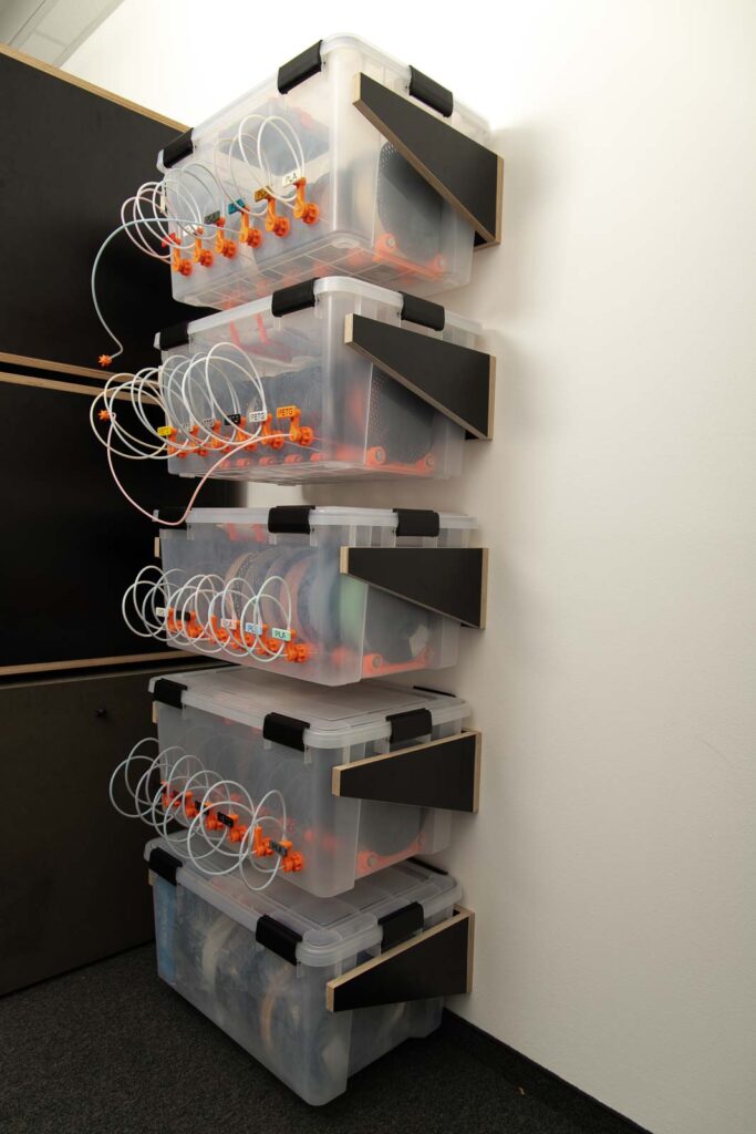 Fünf Wandhalterungen für Filament Trockenboxen übereinander, alle beladen mit Luftdichten Boxen - 4 davon als Filament Boxen zum direkt Drucken, eine als Lagerbox für Filament. 