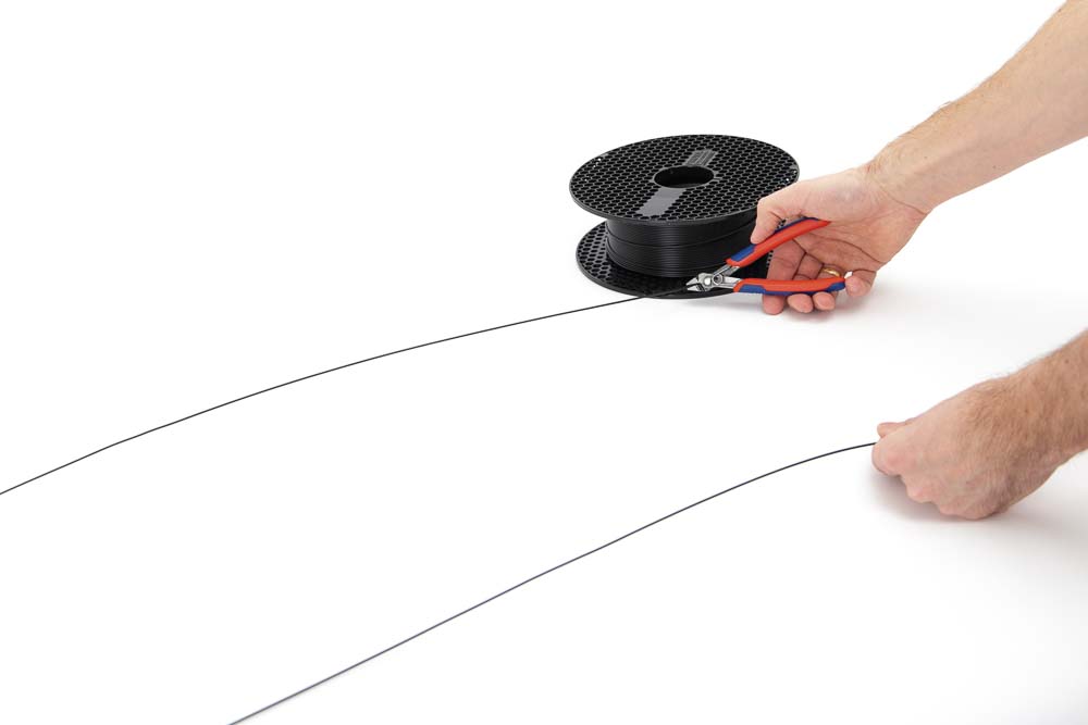 Filament is cut to the desired length for the 3D printed pendant light