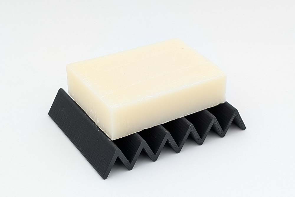 3D Druck Seifenschale, gedruckt in matt schwarzen Filament, zeigt das Design Dreieck und eine darauf platzierte Seife