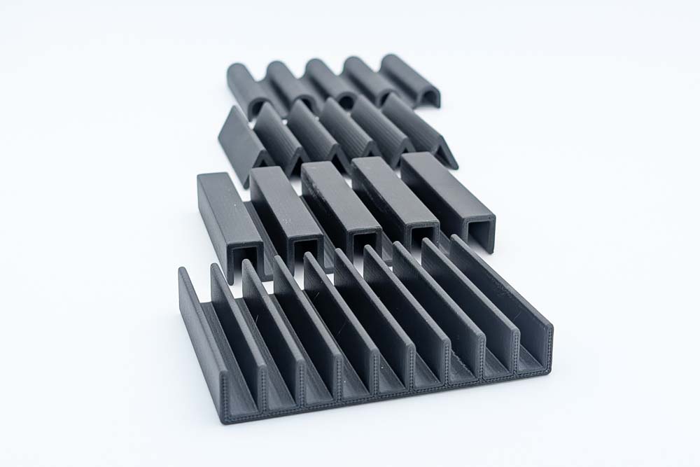 3D Druck Seifenhalter, gedruckt in matt schwarzen Filament, zeigt die vier verschiedenen Designs: Rippen Rechteck, Dreieck und Wellen.