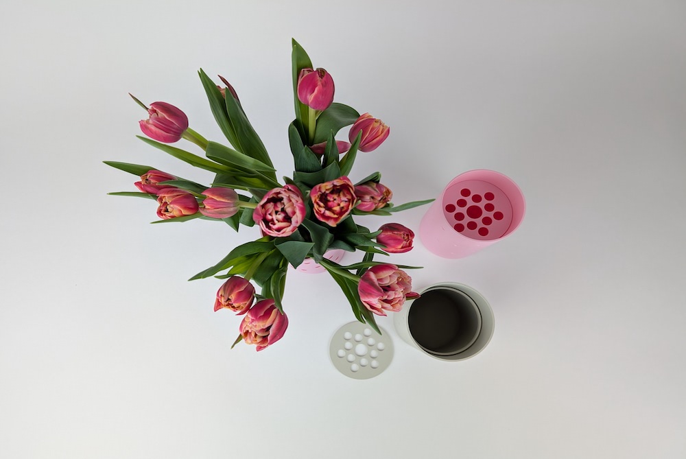 Alle Varianten der 3D Druck Blumenvasen mit Herzen, in rot erhaben und vertieft in rosa und beige. Alle von oben Fotografiert, eine Vase ist mit Blumen gefüllt.