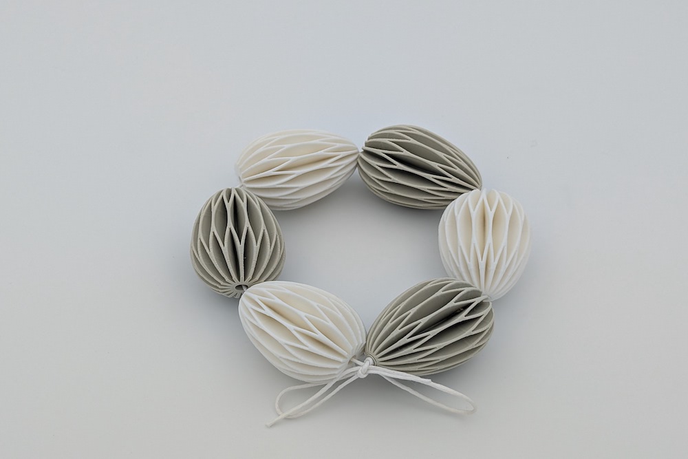 Kranz aus gedruckten, kleinen Ostereiern in den Farben beige und weiß